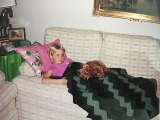 ceo of allergy defender as a girl with dog on lap laying on couch