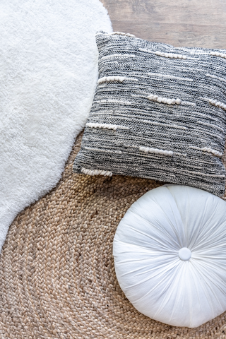 two pillows with two rugs on floor