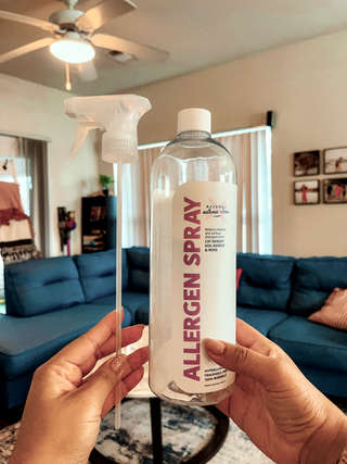 hands holding allergen spray bottle showing minerals in bottom of bottle