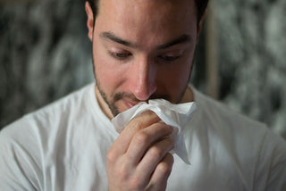 man sneezed with tissue in hand