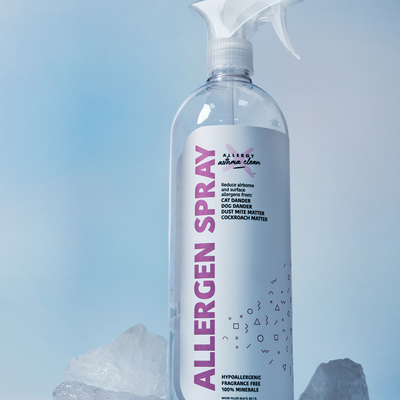 Allergen spray bottle with crystals on a light blue background